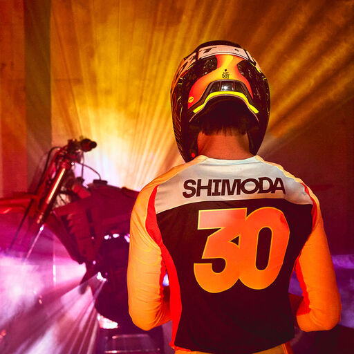 Jo Shimoda facing a dirt bike