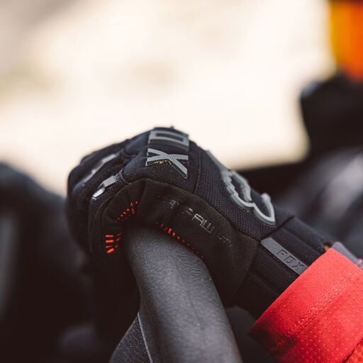 Close up view of hand holding a steering wheel.