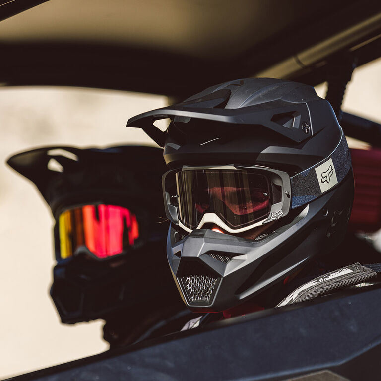 Two people in a side by side wearing helmet and goggles.