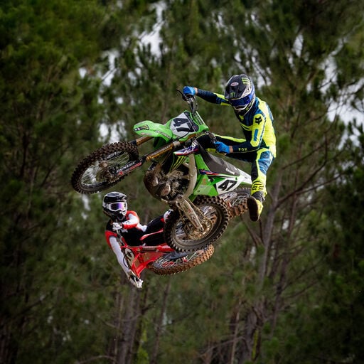 Dirt bikers scrubbing a jump.