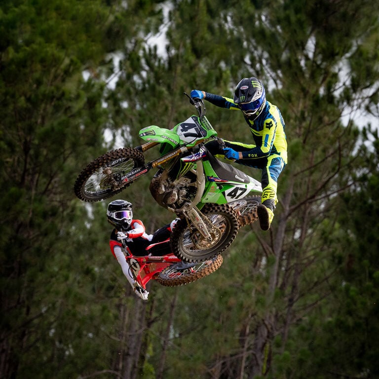 Dirt bikers scrubbing a jump.