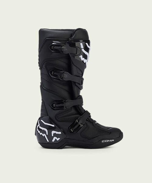 Black motocross boot on green background