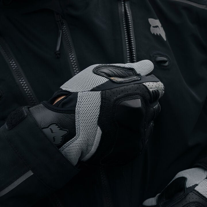 gloved hand zipping up an adv jacket