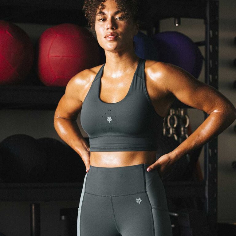 Woman at the gym wearing sports bra and leggings.
